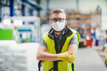 Portrait Mann Arbeiter mit Schutzmaske stehend in industrieller Fabrik oder Lager. - HPIF15028