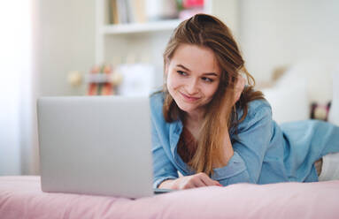 Beautiful happy young girl with laptop sitting and smiling, online dating and chatting concept. - HPIF15051