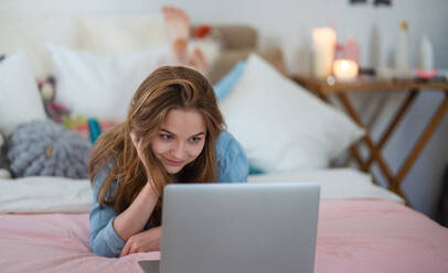 Beautiful happy young girl with laptop sitting and smiling, online dating and chatting concept. - HPIF15052