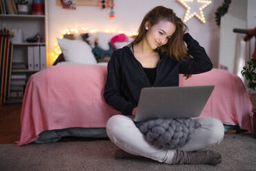 Beautiful happy young girl with laptop sitting and smiling, online dating and chatting concept. - HPIF15061