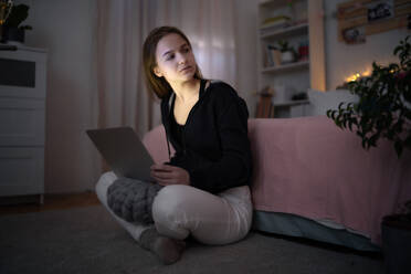 Worried young girl with laptop sitting and smiling, online dating and internet abuse concept. - HPIF15064