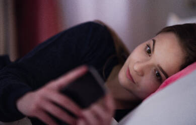 A young girl using smartphone on bed, online dating concept. - HPIF15076