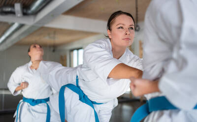 Eine Gruppe junger Frauen übt in einer Turnhalle Karate. - HPIF15097