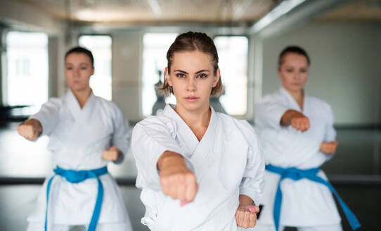 Eine Gruppe junger Frauen übt in einer Turnhalle Karate. - HPIF15105