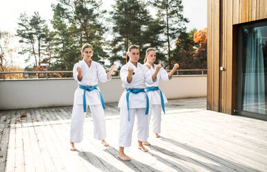 Eine Gruppe junger Frauen übt Karate im Freien auf einer Terrasse. - HPIF15116