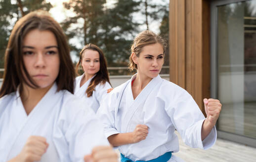 Eine Gruppe junger Frauen übt Karate im Freien auf einer Terrasse. - HPIF15118