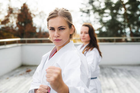 Eine Gruppe junger Frauen übt Karate im Freien auf einer Terrasse. - HPIF15119