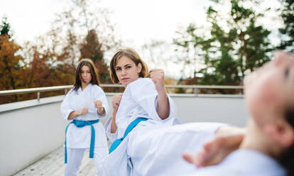 Eine Gruppe junger Frauen übt Karate im Freien auf einer Terrasse. - HPIF15127