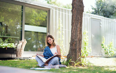 Happy mature woman working in home office outdoors in garden, resting. - HPIF15178