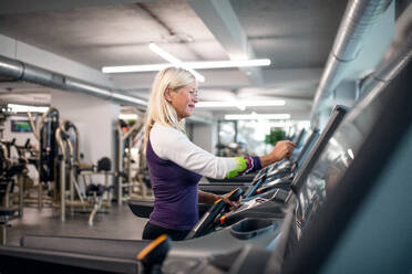 A happy senior woman in gym doing cardio work out exercise. - HPIF15207