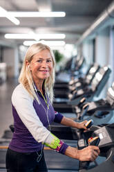 A happy senior woman in gym doing cardio work out exercise. - HPIF15210