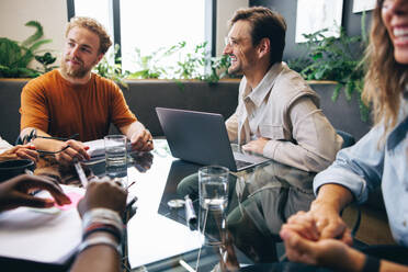 Group of business professionals, male and female, meeting in a boardroom to discuss strategies and plans for future growth. Professional team collaborating on a project in a modern office. - JLPPF01943