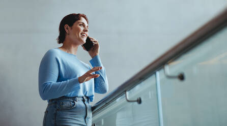 Successful business woman suing her strong communication and negotiating skills to secure a business deal for her company. Happy female professional connecting with her business partners with a mobile phone. - JLPPF02028