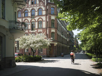 Radfahrende Frau auf der Straße in Malmö, Schweden - FOLF12199