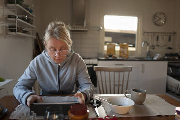 Frau liest Tablet-PC am Frühstückstisch - FOLF12262
