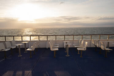Chairs and tables on ferry during sunset - FOLF12268