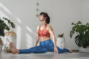 Reife Frau übt Yoga und macht Spagat - SNF01651