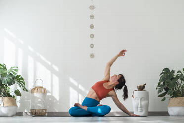Reife Frau übt Yoga sitzend vor einer Wand - SNF01662
