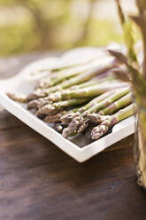 Fresh asparagus arranged in white tray - ONAF00535