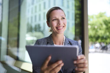 Smiling businesswoman holding tablet PC - PNEF02869