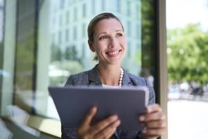 Lächelnde Geschäftsfrau mit Tablet-PC - PNEF02869