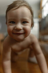 Nettes lächelndes Baby Mädchen krabbelt im Schlafzimmer - IEF00394