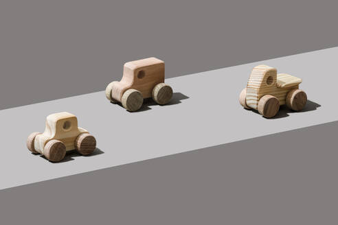 Wooden cars on gray background - FLMF00971