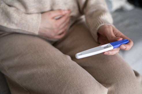 Frau prüft Schwangerschaftstestkit - VPIF08025