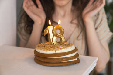 Geburtstagskuchen mit angezündeter Kerze Nummer 18 zu Hause - VPIF08038