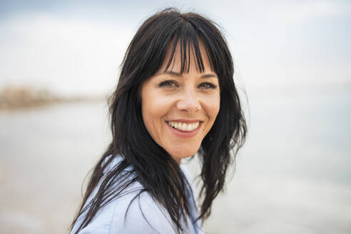 Happy woman with toothy smile at beach - JOSEF19237