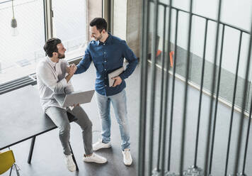 Geschäftskollegen halten sich am Tor im Büro an den Händen - UUF28673