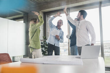 Happy business colleagues giving high-five in office - UUF28717