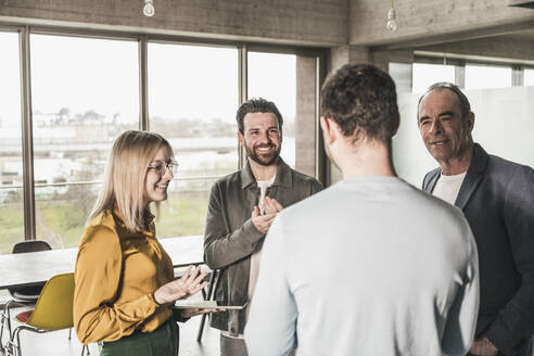 Team applaudiert einem Kollegen im Büro - UUF28733