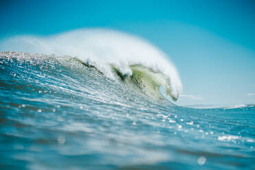 Powerful foamy sea waves rolling and splashing over water surface against cloudy blue sky - ADSF44142