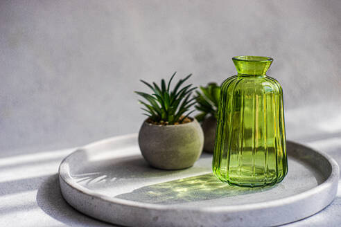 Minimalistisches Stillleben mit grüner Glasvase und Mini-Kaktuspflanzen - ADSF44145