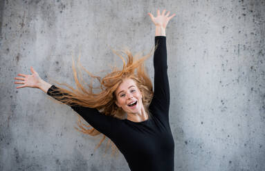 Front view portrait of cheerful young woman with red hair standing against gray background. - HPIF15444