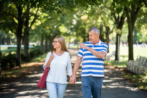 Frontansicht Porträt der glücklichen Senior Paar zu Fuß im Freien in der Stadt oder Stadtpark. - HPIF15483
