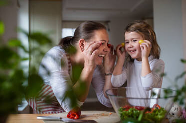 Small girl with senior grandmother in kitchen indoors at home, having fun when cooking. - HPIF15543