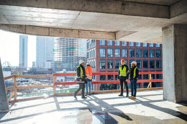 A group of engineers standing on construction site, talking. - HPIF15594
