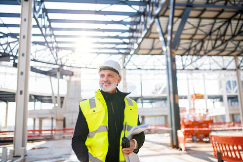 Vorderansicht eines Ingenieurs mit Walkie-Talkie auf einer Baustelle. - HPIF15628