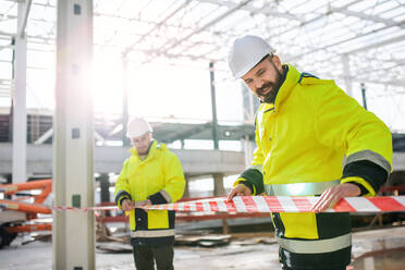 Männer, die im Freien auf einer Baustelle stehen und im Winter arbeiten. - HPIF15645