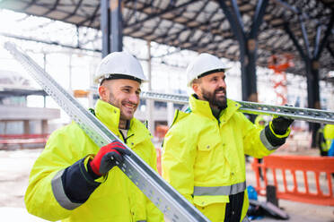 Men workers walking outdoors on construction site, working in winter. - HPIF15648