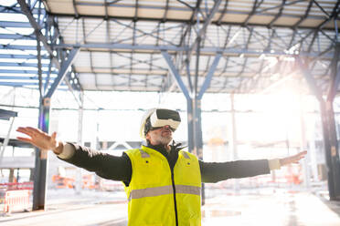 Ein Ingenieur benutzt eine VR-Brille im Freien auf einer Baustelle. - HPIF15664