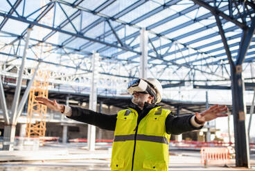 Ein Ingenieur benutzt eine VR-Brille im Freien auf einer Baustelle. - HPIF15665