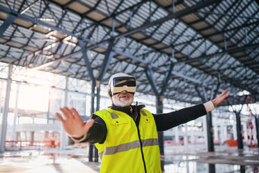 Ein Ingenieur benutzt eine VR-Brille im Freien auf einer Baustelle. - HPIF15666