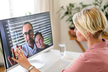 Junge Frau führt Videogespräch mit Ehemann und kleinem Sohn, Konzept der sozialen Distanzierung. - HPIF15738