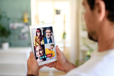 Midsection of unrecognizable man having video call on tablet at home. - HPIF15750