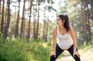 Frontansicht Porträt der glücklichen schwangeren Frau im Freien in der Natur, tun Übung. - HPIF15827