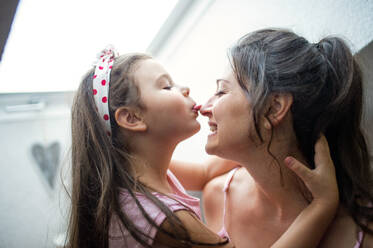 Portrait of mother and small daughter indoors at home, having fun. - HPIF15915