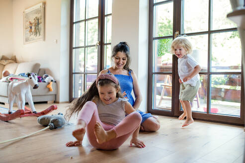 Glückliche schwangere Frau mit kleinen Kindern, die zu Hause spielen. - HPIF15943